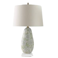 Port68 Ghost Blossom table lamp with a soft green and blue porcelain base, aged brass hardware, clear lucite base, and off-white drum shade.