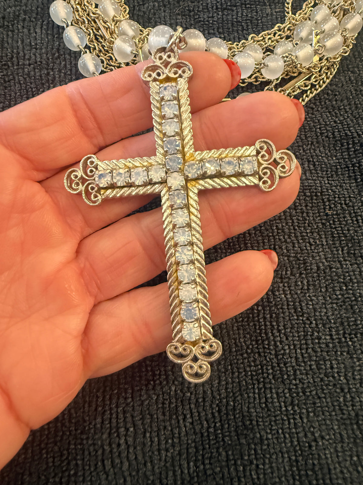 Close-up of Made in the Deep South necklace featuring a repurposed 1950s AB rhinestone cross pendant and vintage Kramer necklace with original identification tag.