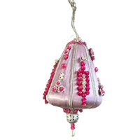 Close-up of fuchsia beadwork, pearl-look accents, silver-tone ribbon, and loose threads on a vintage lilac satin-thread ornament.