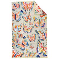 Crae.Home Floatie reversible hand towel hanging with colorful whimsical fish print on a cream background and pink floral reverse