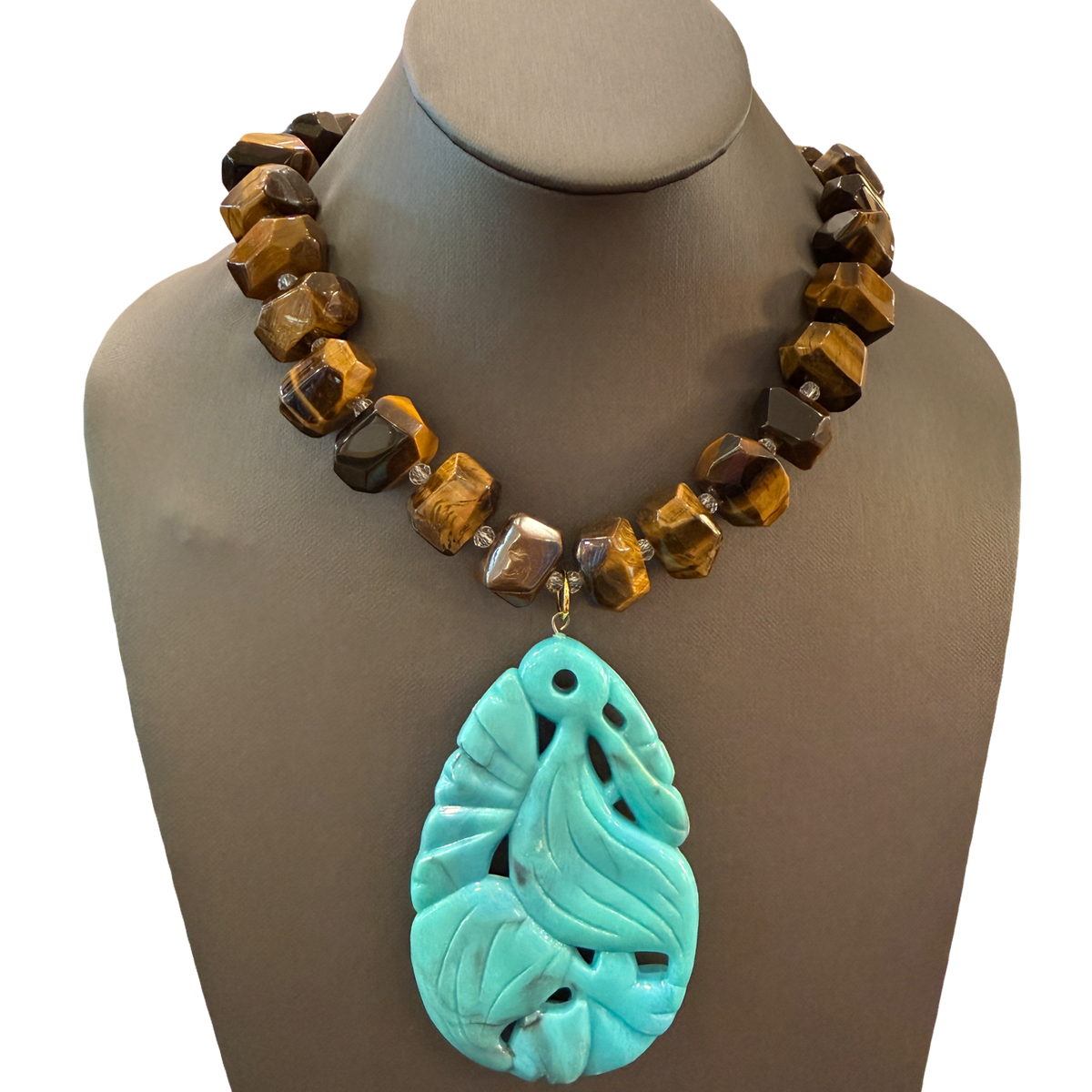 Made in the Deep South necklace with faceted brown tiger’s eye beads, clear spacers, and an oversized turquoise-blue leaf pendant.