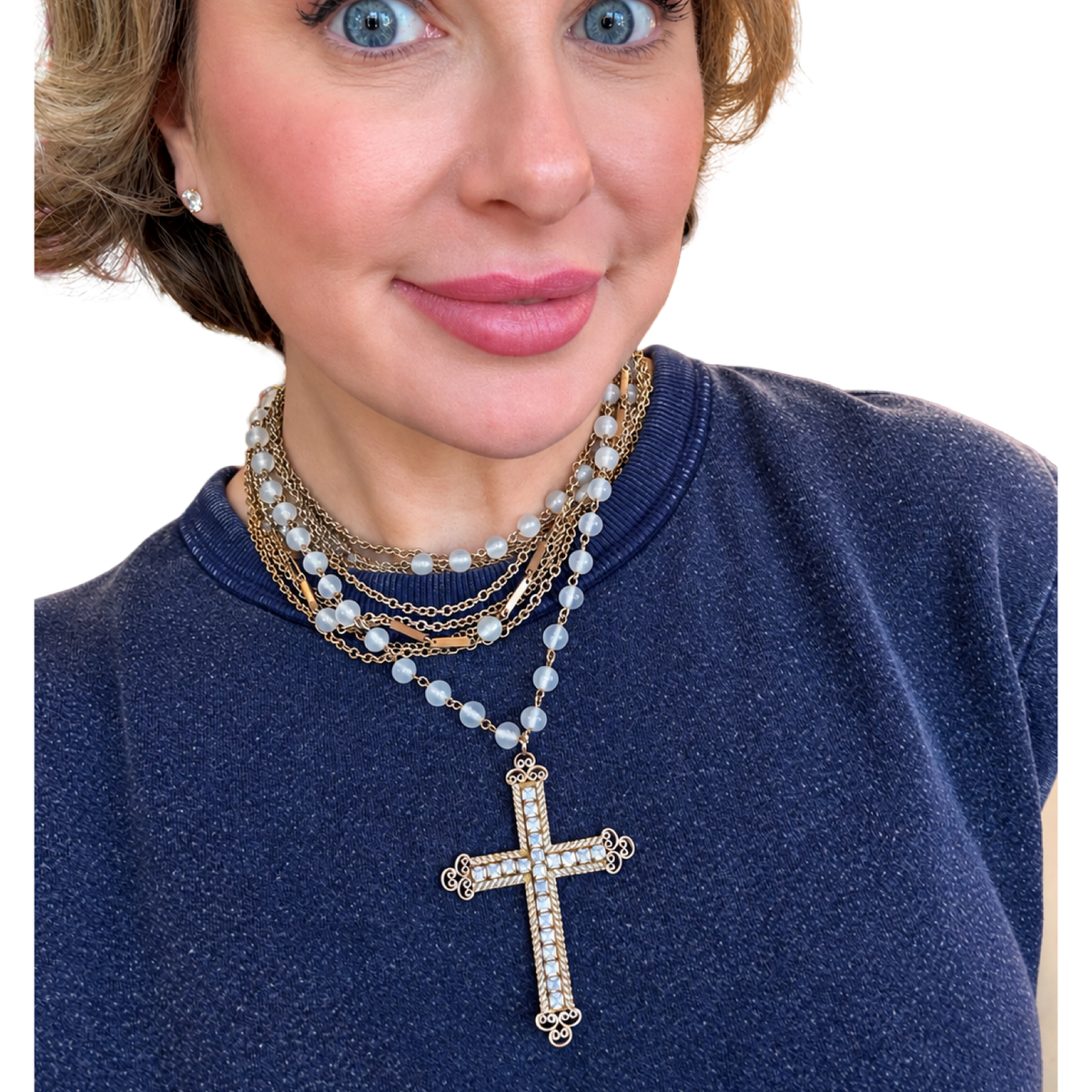 
Meredith wearing the one-of-a-kind Made in the Deep South vintage 1950s rhinestone cross necklace, showcasing its sparkling pendant and delicate beaded design styled with layered jewelry.