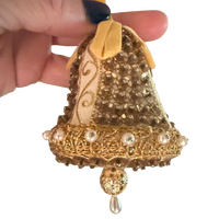 Vintage gold and ivory bell ornament with sequins, pearl-look trim, a yellow ribbon loop, and a dangling teardrop.
