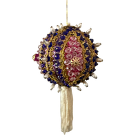 Vintage round ornament with purple beads, pink sequins, gold-tone braid, pearl-look accents, and an ivory tassel hanging from a gold cord.