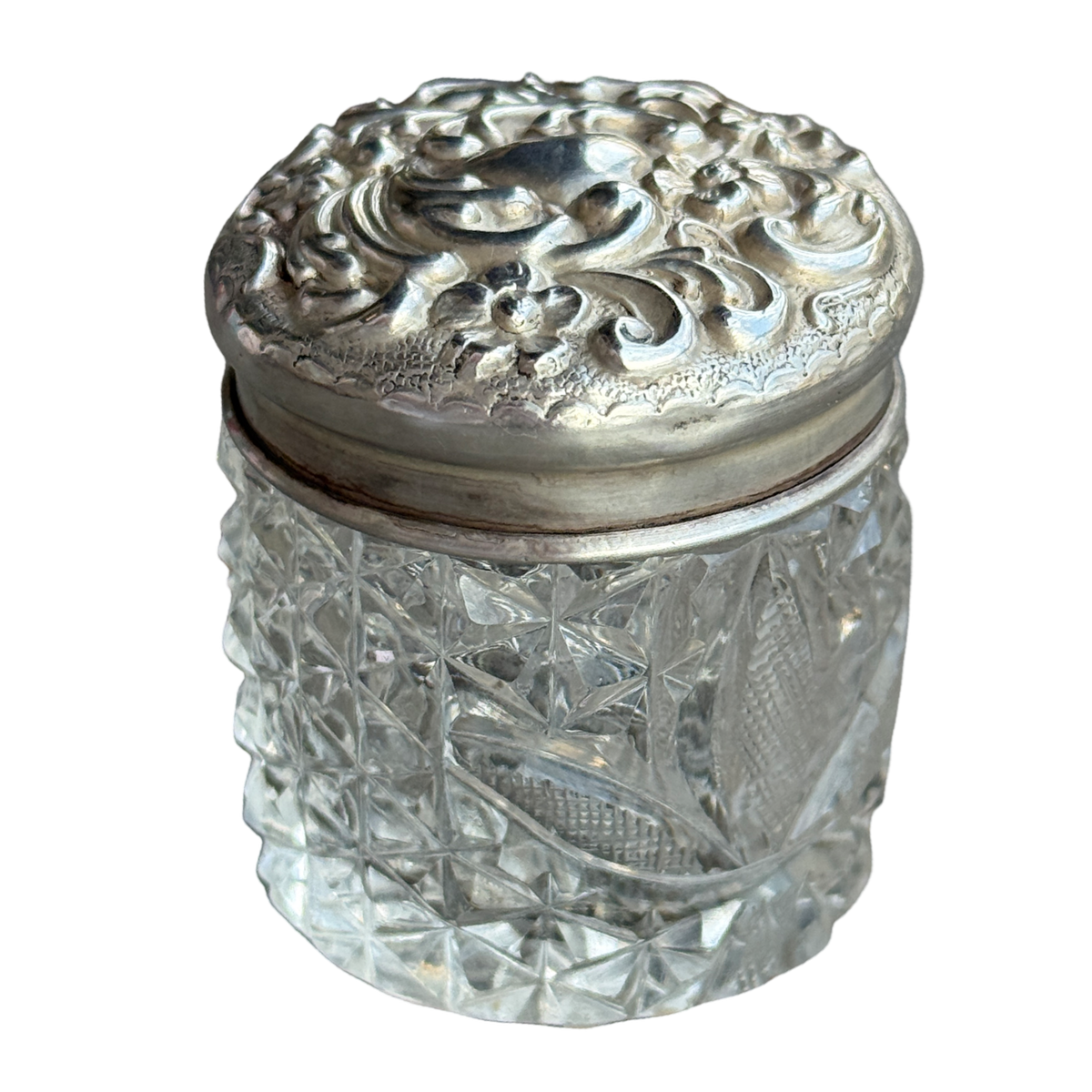 Decorative glass jar with a silver lid on a white background