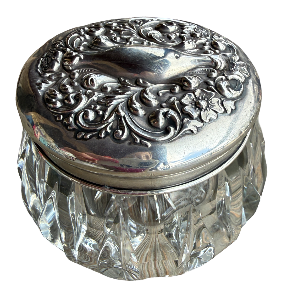 Decorative glass jar with an ornate silver lid on a white background