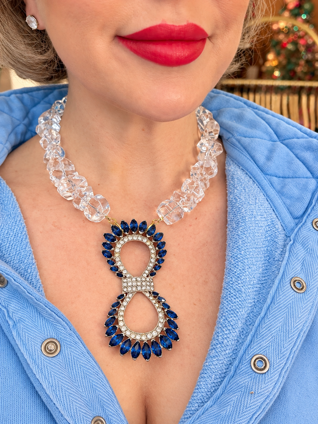 Close-up of one-of-a-kind sapphire-blue vintage brooch and chunky clear quartz necklace worn at the neckline