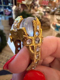 Made in the Deep South vintage ring with a gray cabochon and gold-tone cross set with clear faceted accents.