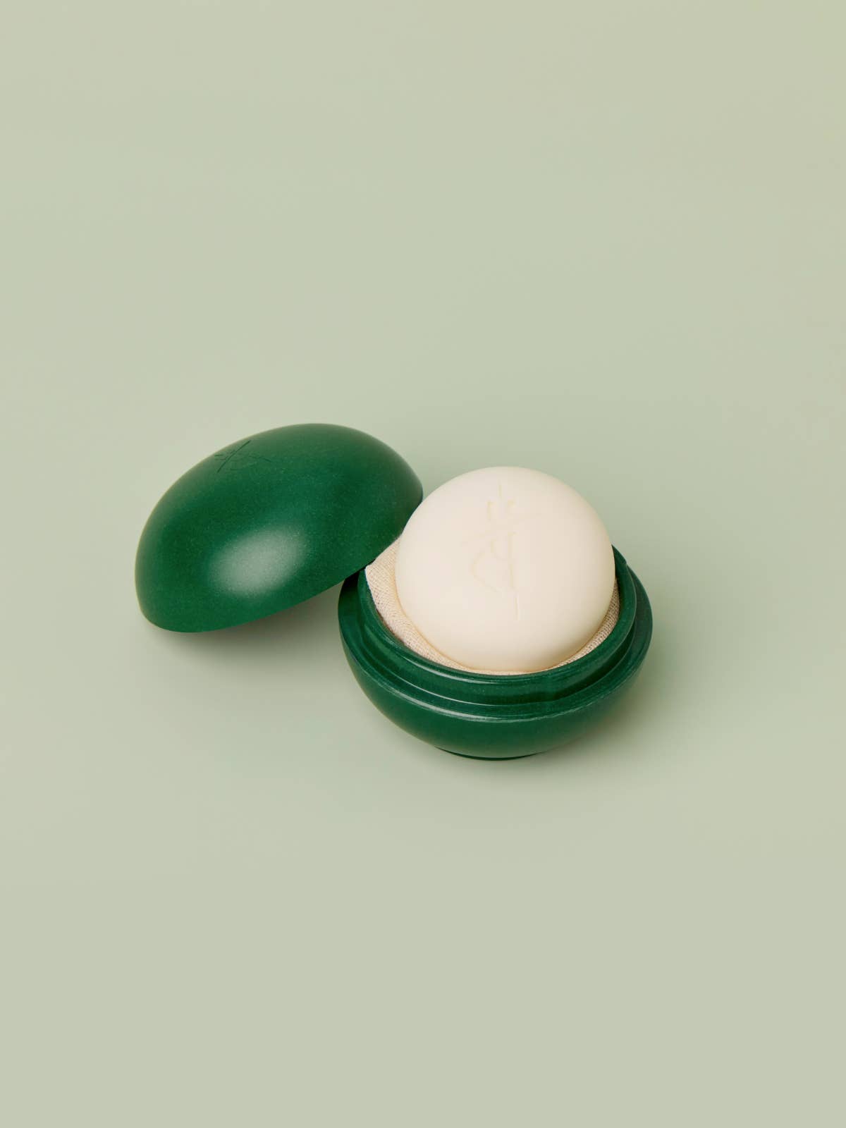 Kate McLeod Body Stone Travel Case in Mint and Pine with a subtly speckled finish and embossed logo.