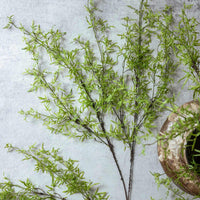 Artificial greenery branches on a textured surface