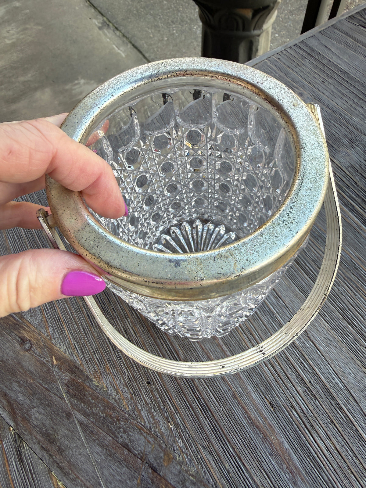 Hand holding a decorative metal mesh over a textured surface