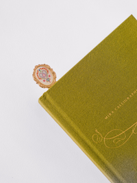 Good Juju Ink Folk Heart Metal Clip Bookmark with colorful heart illustration and gold-tone finish in patterned gift packaging