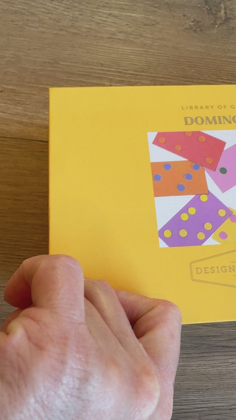 boxed dominoes game, tabletop dominoes set, stylish dominoes gift, classic domino game, colorful wooden dominoes, gold foil domino set, family game night essentials, design-focused dominoes, giftable board games, modern domino set
