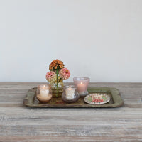 Decorative tray with candles and flowers on a wooden surface