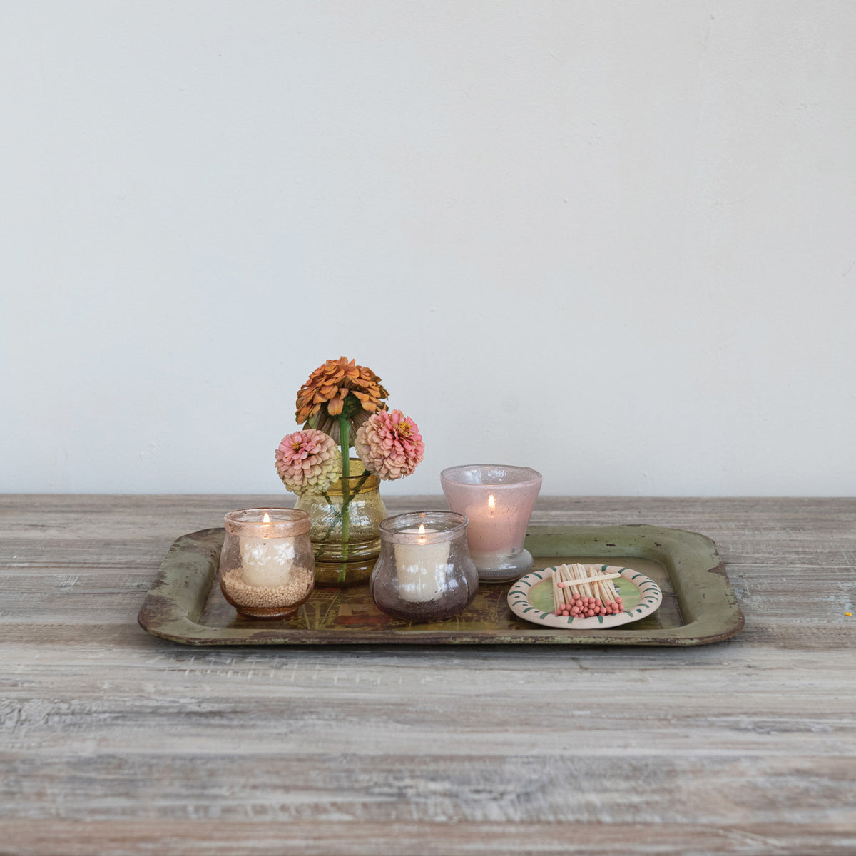 Decorative tray with candles and flowers on a wooden surface
