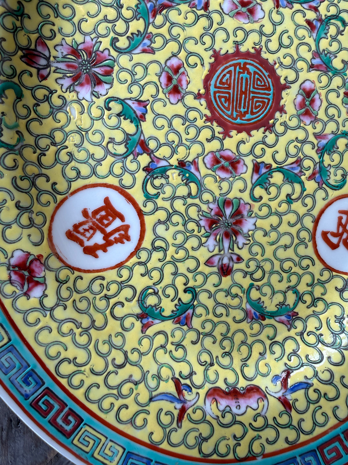 Decorative plate with intricate floral and swirling patterns on a yellow background