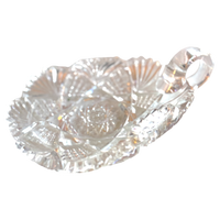 Clear glass candy dish with leaf design on a white background