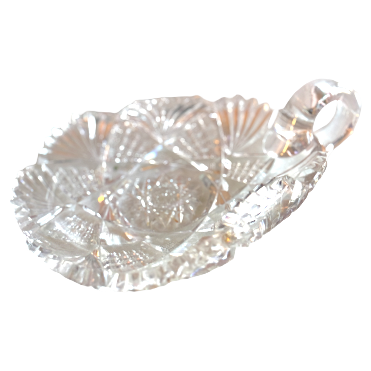Clear glass candy dish with leaf design on a white background