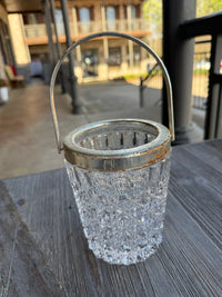 Clear glass object with metal base on a textured surface